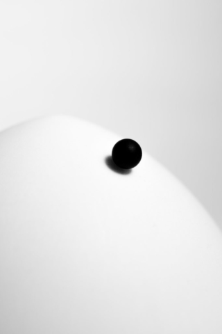 A black sphere on a white dome, gradually rolling down. At a glance, they seem perfect abstractions, but closer inspection reveals the rough texture and imperfection of real objects, actually existing.