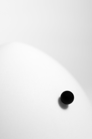 A black sphere on a white dome, gradually rolling down. At a glance, they seem perfect abstractions, but closer inspection reveals the rough texture and imperfection of real objects, actually existing.